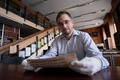 オーストリア・ハンガリーの首都ブダペスト（Budapest）にある国立セーチェーニ図書館（National Szechenyi Library）で撮影された、作曲家ウォルフガング・アマデウス・モーツァルト（Wolfgang Amadeus Mozart）の「ピアノ・ソナタ第11番イ長調K.331」の自筆譜とされる楽譜の一部を手にする同図書館の職員（2014年9月17日撮影）。(c)AFP/ATTILA KISBENEDEK