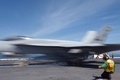 大西洋を航行する米空母ジョージ・H・W・ブッシュの甲板で、米海軍のF18戦闘機「ホーネット」を誘導して離艦させるカタパルト担当官（2018年5月11日撮影）。(c)AFP / Eric Baradat