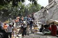 メキシコの首都メキシコ市で、地震により倒壊した建物のがれきを撤去し、被災者を探す人々（2017年9月19日撮影）。(c)AFP/Omar TORRES