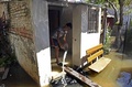 大規模な洪水に見舞われたパラグアイの首都アスンシオンの地区で、自宅から水をかき出す若者（2015年12月24日撮影）。(c)AFP/NORBERTO DUARTE