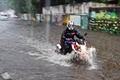 大型サイクロンの豪雨により冠水したインド西部ムンバイの道路をバイクで走る人（2021年5月17日撮影）。(c)Indranil MUKHERJEE / AFP