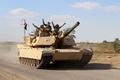 イラクのアンバル州ヒートから数キロ北のモハマディ村で軍用車両の上でVサインを見せる政府の治安部隊員ら（2016年3月18日撮影）。(c)AFP/MOADH AL-DULAIMI