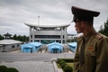 南北軍事境界線の北朝鮮側の板門店付近で、韓国側を見つめる朝鮮人民軍の中佐（2018年6月11日撮影）。(c)AFP PHOTO / Ed JONES