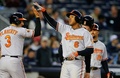 14MLB、ニューヨーク・ヤンキース（New York Yankees）対ボルチモア・オリオールズ（Baltimore Orioles）。2回に先制の3点本塁打を放ち、チームメートに出迎えられるボルチモア・オリオールズのジョナサン・スクープ（Jonathan Schoop、2014年4月9日撮影）。(c)AFP/Getty Images/Jim McIsaac