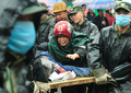 四川大地震に見舞われた中国南西部の四川（Sichuan）省都江堰（Dujiangyan）で、倒壊した学校の下敷きになって死亡したわが子の遺体に手を伸ばして悲嘆にくれる母親。（2008年5月13日撮影）。(c)AFP/TEH Eng Koon
