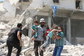 シリア北部アレッポで、反体制勢力が制圧する東部マーディ地区のがれきから子供を救い出す人々（2016年8月25日撮影）。(c)AFP/AMEER ALHALBI