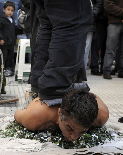 痛い痛い!?ガラスの上に横たわる男性 アルゼンチン