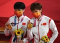 東京五輪、自転車トラック女子チームスプリントの表彰式で、毛沢東のバッジをつける中国の鮑珊菊（左）と鍾天使（2021年8月2日撮影）。(c)Greg Baker / AFP