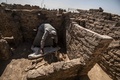 エジプト・ルクソール近郊で発見された古代都市遺構で、動物の骨にカバーをかける作業員（2021年4月10日撮影）。(c)Khaled DESOUKI / AFP