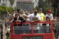 08-09NBAファイナルを制したロサンゼルス・レイカーズ（%%Los Angeles Lakers%%）の優勝パレードが17日、ロサンゼルス（Los Angeles）で行われ、数万人ものバスケットボールファンが祝福のため、市内中心部に詰めかけた。レイカーズの本拠地ステープルズ・センター（Staples Center）から始まったパレードは、8万人のファンが待つロサンゼルス・メモリアル・コロシアム（Los Angeles Memorial Coliseum）まで行われ、数百人の警察官が動員され。写真はバスからファンの声援に応える元レイカーズのマジック・ジョンソン（%%Magic Johnson%%）。（2009年6月17日撮影）(c)AFP/Getty Images/NBAE/Andrew D. Bernstein