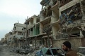 シリアの首都ダマスカス近郊の反体制派支配地区、東グータで、政権軍による空爆後、損壊した建物の横を歩く男性（2018年2月25日撮影）。(c)AFP PHOTO / HAMZA AL-AJWEH
