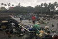 台風22号（アジア名：マンクット）の被害を受けた台湾・台東県の漁港で、散乱したがれきの中に立つ住民ら。CNA提供（2018年9月15日撮影）。(c)AFP PHOTO / CNA / CNA PHOTO