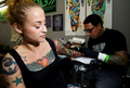 ロンドン（London）で25日から第5回「ロンドン・タトゥー・コンベンション（London Tattoo Convention）」が開催され、米国、オーストラリア、カナダ、日本、英国から多数のタトゥーアーティストが参加した。会場にはタトゥー愛好家やボディピアスの専門家、ファッションデザイナーなどの姿も見られた。主催者によると、本大会では「1か所で新たにタトゥーを施した人の数」で世界最多記録の樹立を目指しているという。

写真は、ロンドンで開催された第5回「ロンドン・タトゥー・コンベンション」でタトゥーを入れる女性（2009年9月26日撮影）。(c)AFP/Leon Neal