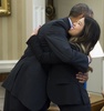 米ワシントンD.C.（Washington D.C.）ホワイトハウス（White House）の大統領執務室（Oval Office）で、エボラ出血熱から回復した看護師のニーナ・ファム（Nina Pham）さん（右）を抱きしめるバラク・オバマ（Barack Obama）米大統領（左、2014年10月24日撮影）。(c)AFP/Saul LOEB