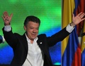 コロンビア・ボゴタ（Bogota）で、大統領選の決選投票での勝利が判明した後、「平和」と書いた手のひらを掲げて支持者に応えるフアン・マヌエル・サントス（Juan Manuel Santos）大統領（2014年6月15日撮影）。(c)AFP/Guillermo LEGARIA