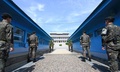 朝鮮半島を南北に隔てる軍事境界線上の板門店に立つ、韓国軍兵士（前方）と北朝鮮軍兵士（後方、2018年4月26日）。(c)AFP / Korea Summit Press Pool