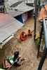 インドネシア・ジャカルタのジャティネガラ地区で、洪水で浸水した家屋から、強い流れにあらがいロープをつかんで避難する住民（2025年3月4日撮影）。(c)BAGUS SARAGIH / AFP