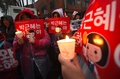 韓国ソウル中心部で、ろうそくを手に朴槿恵（パク・クネ）大統領の退陣を求める抗議デモに参加する市民ら（2016年11月26日撮影）。(c)AFP/JUNG Yeon-Je