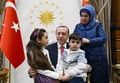 トルコの首都アンカラの大統領府で、レジェプ・タイップ・エルドアン大統領（中央）やエミネ大統領夫人（右）と写真撮影に臨むバナ・アベドさん（左）と弟。トルコ大統領府提供（2016年12月21日撮影・公開）。(c)AFP/Turkish Presidential Press Office/KAYHAN OZER