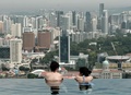 シンガポールの高級リゾートホテルのマリーナ・ベイ・サンズ（Marina Bay Sands）の屋上にある「インフィニティープール（Infinity Pool）」でくつろぐ人々（2014年5月20日撮影）。(c)AFP/ROSLAN RAHMAN