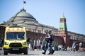 ロシア・モスクワの赤の広場で、マスクをして救急車の前を歩く治安要員ら（2021年6月18日撮影）。(c)Alexander NEMENOV / AFP