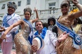 ブラジル・リオデジャネイロ（Rio de Janeiro）で行われたリオのカーニバルの開幕式典に出席した「キング・モモ（King Momo）」役のウィウソン・ジーアス・ダコスタ・ネト（Wilson Dias da Costa Neto）さん（左）とエドゥアルド・パエス（Eduardo Paes）市長（中央右、2014年2月28日撮影）。(c)AFP/YASUYOSHI CHIBA