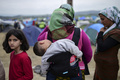食料の配給を列に並んで待つ女性と子ども。(c)AFP/Bulent Kilic
