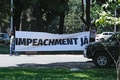 ブラジルの首都ブラジリアで行われたジャイル・ボルソナロ大統領の退陣を求めるデモで、横断幕を掲げる参加者ら（2021年1月23日撮影）。(c)Sergio Lima / AFP