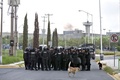 暴動が発生したメキシコ北部ヌエボレオン州カデレイタの刑務所前で待機する暴徒鎮圧用の装備をつけた警察官ら（2017年10月10日撮影）。(c)AFP/Julio Cesar AGUILAR
