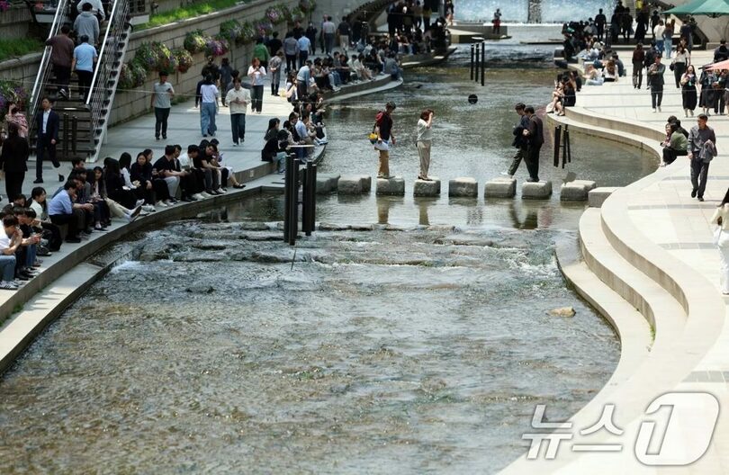 ソウル清渓川で、昼休みに木陰で休憩する会社員(c)news1