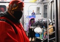 米ニューヨークの地下鉄車内で眠るホームレス（右奥、2020年4月29日撮影）。(c)Angela Weiss / AFP