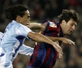 09-10スペイン1部リーグ第24節、FCバルセロナ（%%FC Barcelona%%）対マラガ（%%Malaga CF%%）。試合はバルセロナが2-1で勝利した。写真はマラガのウェリグトン（%%Robson Weligton%%）と競るFCバルセロナのリオネル・メッシ（%%Lionel Messi%%）。（2010年2月27日撮影）(c)AFP/JOSEP LAGO