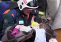 ロシアのマグニトゴルスクで、ガス爆発により崩壊した住居ビルから救出される乳児。同国非常事態省提供の動画から抜粋（2019年1月1日撮影）。(c)AFP PHOTO / RUSSIAN EMERGENCY SITUATIONS MINISTRY