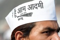 インド・ニューデリー（New Delhi）で行われたデリー首都圏首相に就任する新政党「庶民党（Aam Aadmi Party、Common People&apos;s Party）」のアルビンド・ケジリワル（Arvind Kejriwal）党首の宣誓式に集まった群集の1人。庶民党のトレードマークになっている白いガンジー帽をかぶっている（2013年12月28日撮影）。(c)AFP/RAVEENDRAN