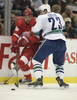 カナックスの%%Alexander Edler%%（右）のチェックを受けるレッドウィングスのトーマス・ホルムソトラム（%%Tomas Holmstrom%%、左）。(c)AFP/Getty Images/Claus Andersen