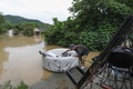 川の氾濫で水没した自宅から荷物を運び出す人。米ケンタッキー州ジャクソンで（2022年7月28日撮影）。(c)LEANDRO LOZADA / AFP