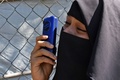 バングラデシュ・ウキヤで、ロヒンギャ難民の移送が始まる前にキャンプ内の家族と電話で話す女性（2020年12月3日撮影）。(c)Munir Uz Zaman / AFP
