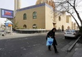 イランの首都テヘランで閉鎖されたモスク（イスラム礼拝所）の脇を通る女性（2020年3月13日撮影）。(c)STR / AFP