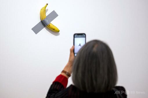 壁にテープで張られた数億円のバナナ、来館者に食べられる 仏 写真2枚