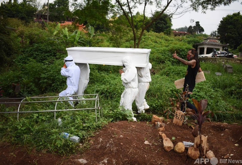 【今日の1枚】次から次へと埋葬、疲弊する墓地の作業員たち