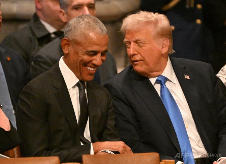米首都のワシントン大聖堂で行われたジミー・カーター元米大統領の国葬で、ドナルド・トランプ大統領（右）と話すバラク・オバマ元大統領（2025年1月9日撮影）。(c)ROBERTO SCHMIDT/AFP