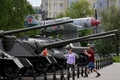 ウクライナ国境から約40キロ離れた、ロシア南部ベルゴロド州の州都ベルゴロドの博物館で、旧ソ連製戦車に座らせた子どもを写真撮影する男性（2023年5月27日撮影、資料写真）。(c)Olga MALTSEVA / AFP