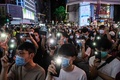 香港・銅鑼湾地区で行われた抗議デモで、歌いながらライトを点灯したスマートフォンを掲げる参加者ら（2020年6月12日撮影）。(c)Anthony WALLACE / AFP