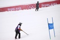 北京冬季五輪、アルペンスキー男子大回転の会場、国家アルペンスキーセンターで、2本目の滑走の前に雪かきをするスタッフ（2022年2月13日撮影）。(c)Fabrice COFFRINI / AFP