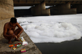 インド・ニューデリー（New Delhi）市内を流れるガンジス川の最大支流、ヤムナー川（Yamuna River）のほとりで供え物を用意するヒンズー教徒（2012年7月14日撮影）。(c)AFP/Andrew Caballero-Reynolds