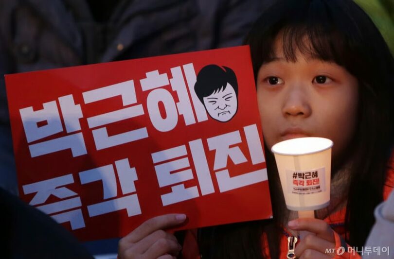 2016年、パク・クネ（朴槿恵）大統領（当時）退陣集会で、ろうそくを手にする少女(c)MONEYTODAY