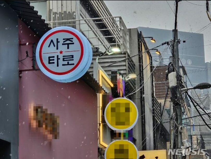 ソウル市江南区新沙洞のある路地。四柱カフェを案内する看板照明が明るく輝いている(c)NEWSIS
