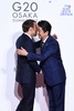 大阪で開催中の20か国・地域（G20）首脳会議の歓迎行事で、エマニュエル・マクロン仏大統領（左）を迎える安倍晋三首相（右、2019年6月28日撮影）。(c)Brendan Smialowski / AFP