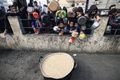 パレスチナ自治区ガザ南部ラファで、食料の配給を待つ人々（2023年12月23日撮影）。(c)MAHMUD HAMS / AFP
