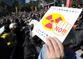 脱原発のスローガン入りのプラカードを掲げる都内で行われた脱原発集会の参加者（2014年3月15日撮影）。(c)AFP/TOSHIFUMI KITAMURA